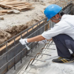 Operário trabalhando na recuperação de armadura oxidada em um canteiro de obras